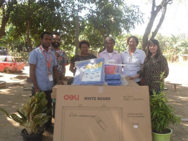 L-R Aquino Saklo Manager Anglicare POM Adult Literacy, Bernard Paru Anglicare POM Branch Manager, SDA Church Rep, Faole Adult Literacy School Erima Chairman Gideon Mii, ADRA Rep Gloria Nema and Ms. Jasmine Simyunn ADRA PNG Country Director. Standing behind the donated School Materials for the out door use by the Adult learners. 