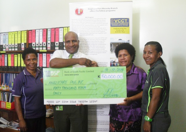Moses Kewa Manager OH&S Operations, Human Resource BSP (2nd from Left) presenting the dummy Cheque of K50,000.00 to Anglicare National Director Mrs. Heni Meke. Looking on are Rosemary Mawe Corporate Sponsorship Manager - Marketing and Public Relations (R) and Carol Habin PA to the National Director (L). 18th December, 2014
